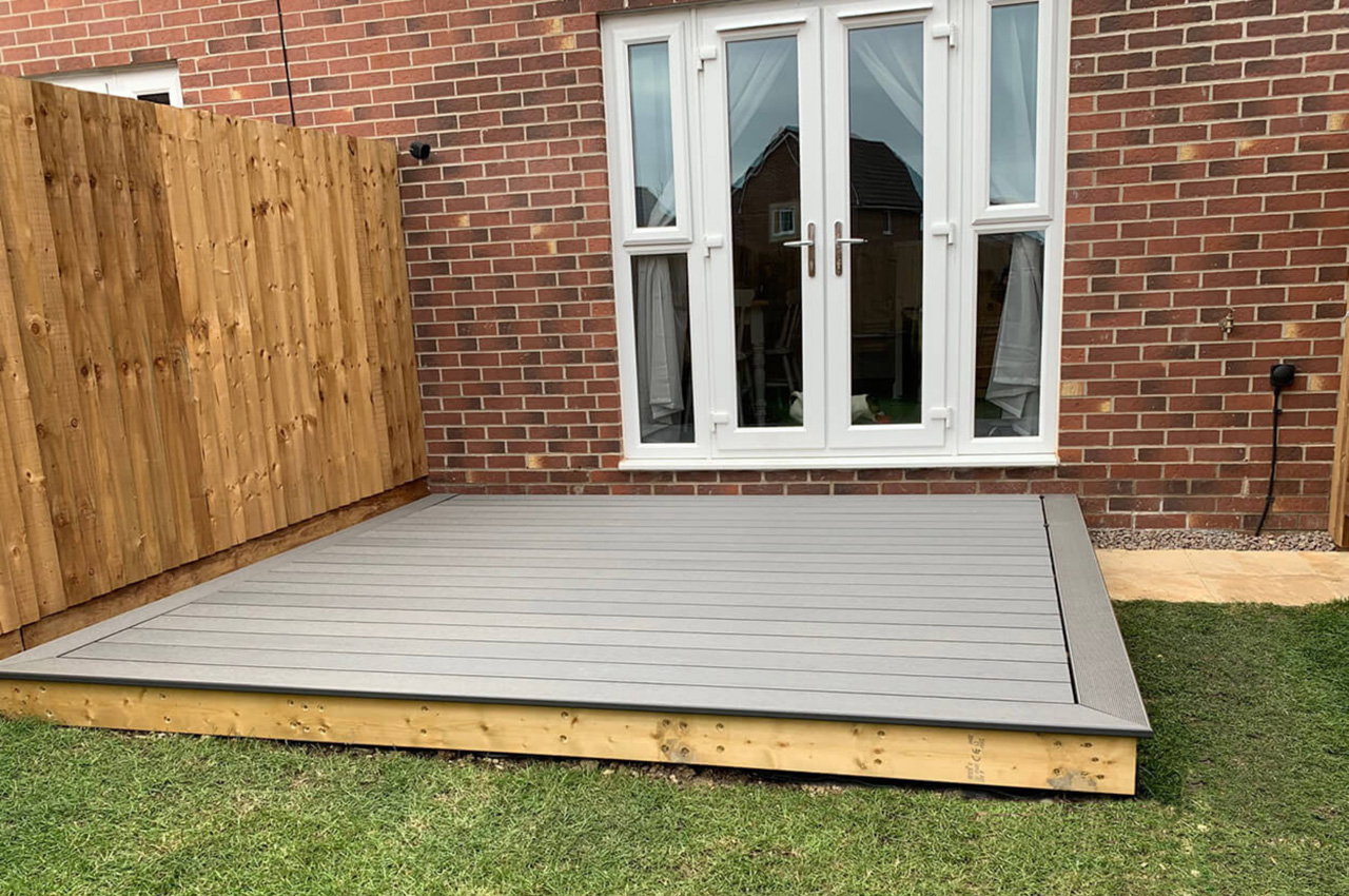 Stone grey composite decking area with dining table and bullnose edge