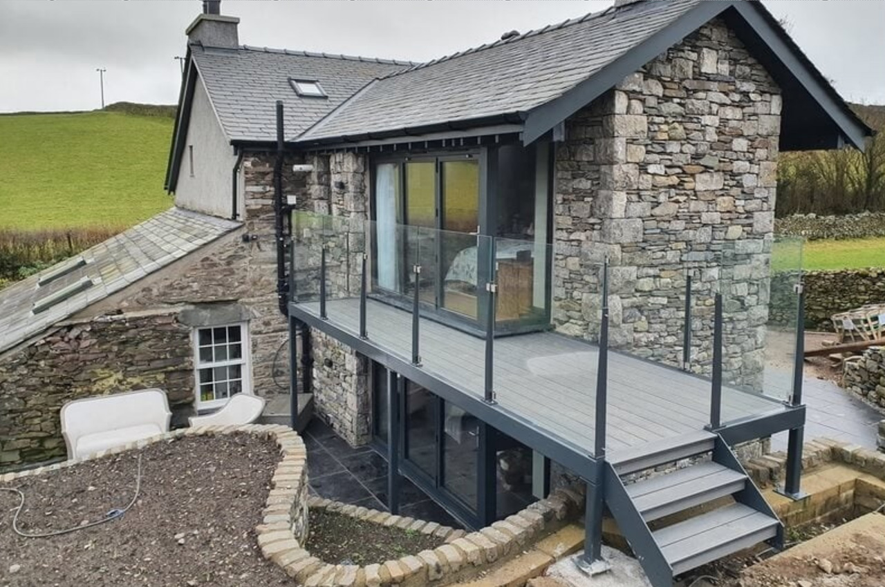 Stone Grey Raised Decking encircles this traditional stone wall cottage.
