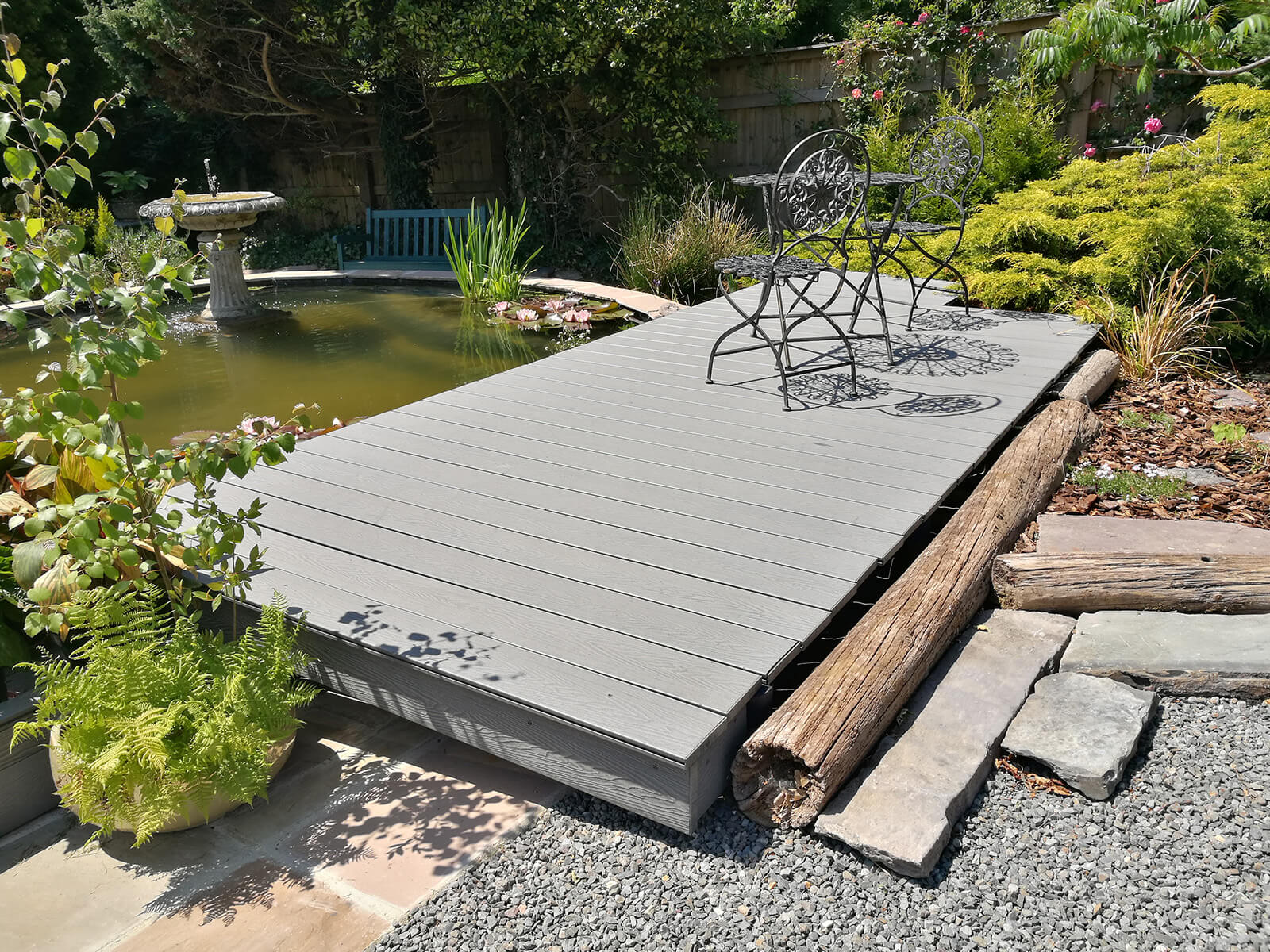 Light Grey Woodgrain Decking by a garden pond and water feature