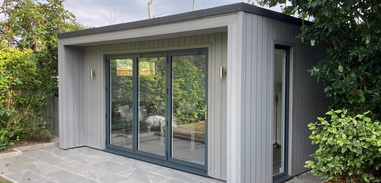 Vertical Composite Wall Cladding in Light Grey features on the exterior of this large garden room 