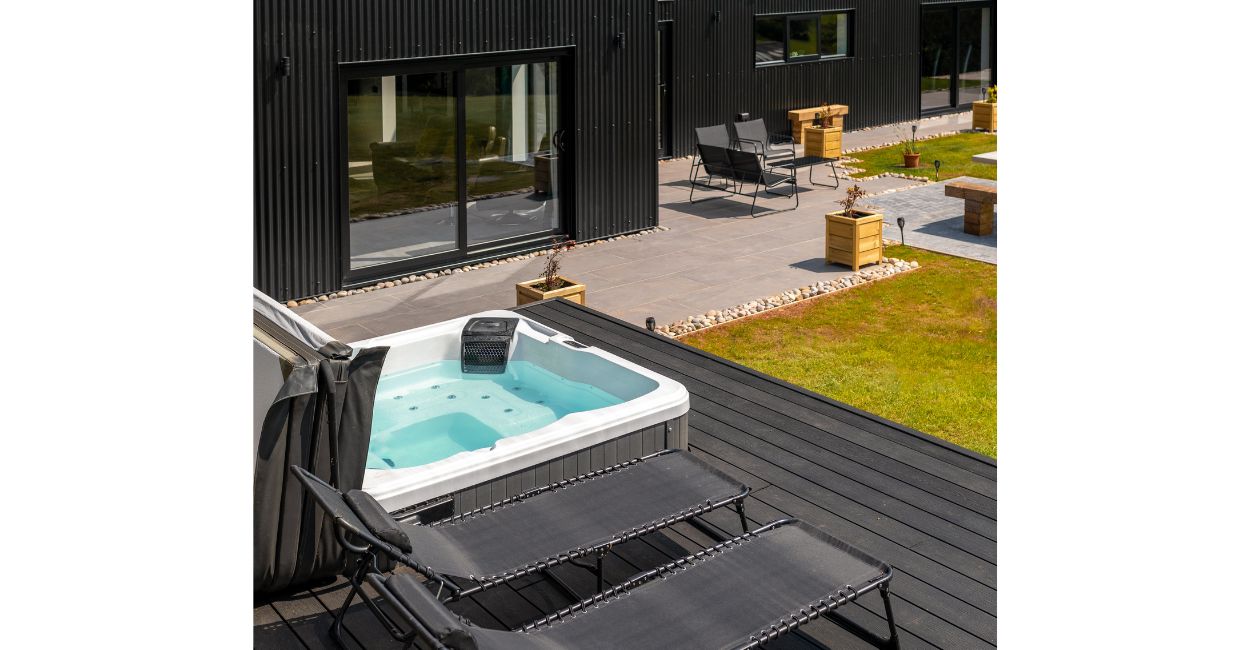 The Black Barn Project uses Cladco Woodgrain Composite Decking in Charcoal for an outdoor hot tub area.