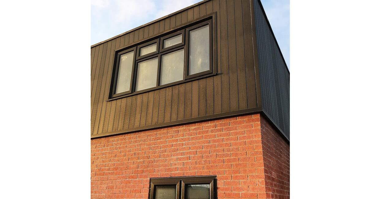Composite Wall Cladding Boards in Charcoal contrast the existing red bricks on this home exterior