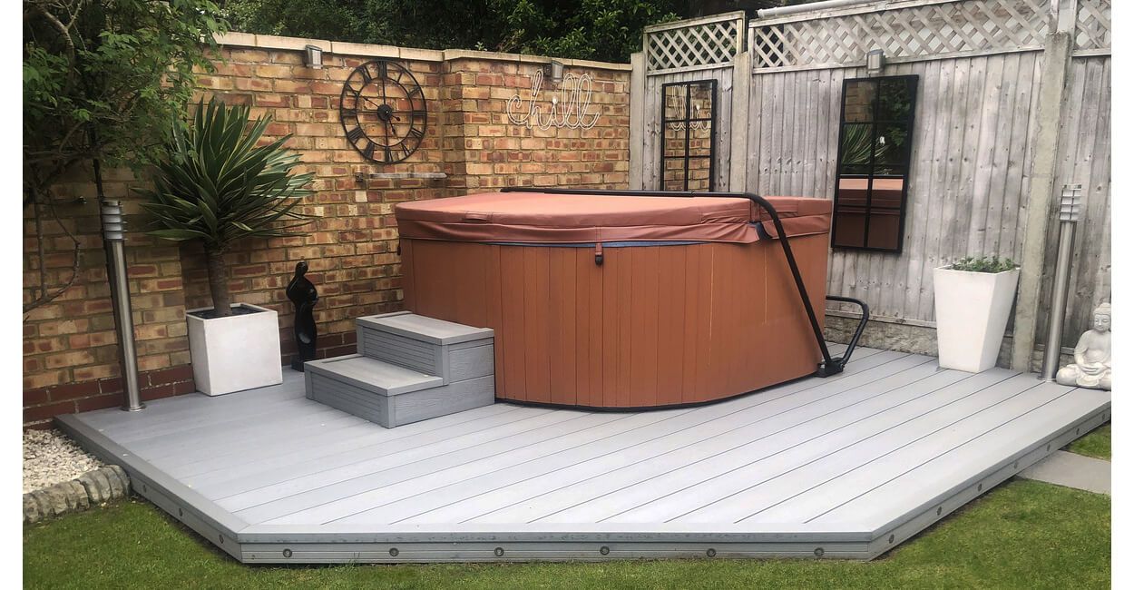 Woodgrain Effect Composite Decking in Light Grey installed around a hot tub 