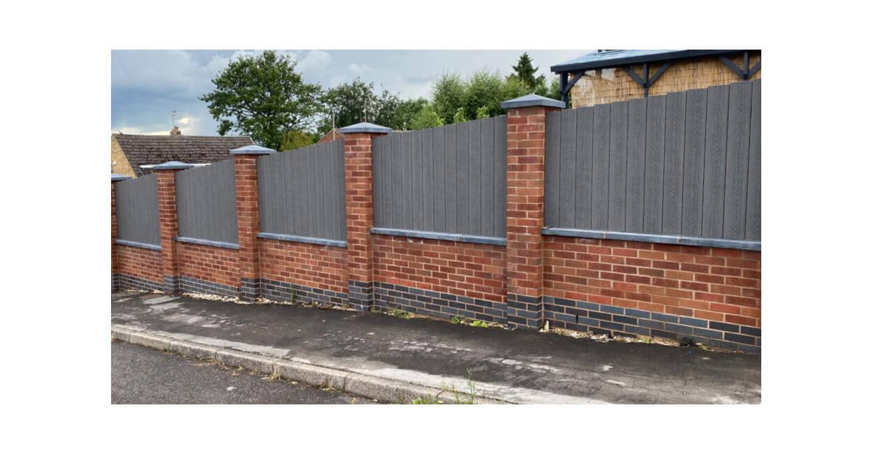 Cladco Woodgrain Composite Decking Boards have been installed as vertical fencing panels around this home