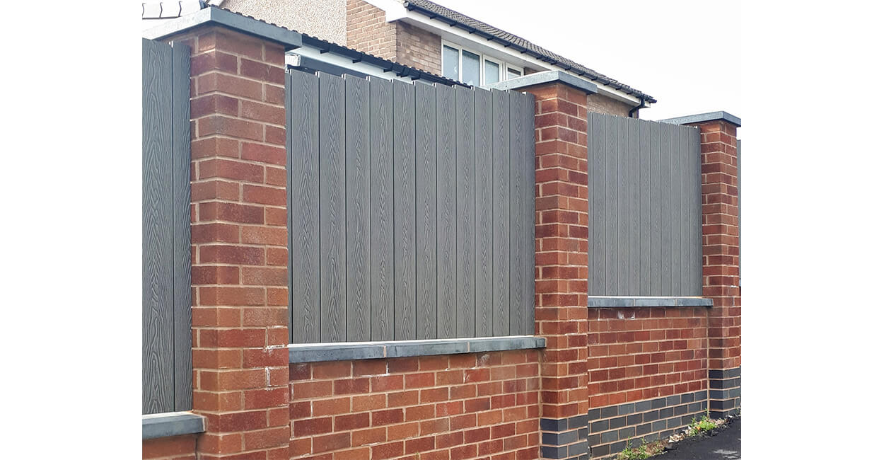 Cladco Woodgrain Composite Decking Boards have been installed as vertical fencing panels around this home