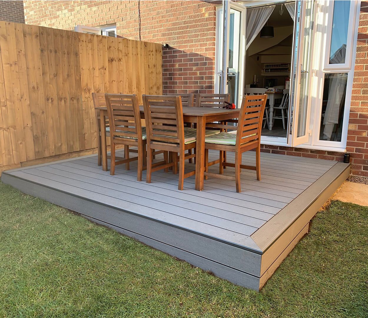 Stone grey composite decking area with dining table and bullnose edge