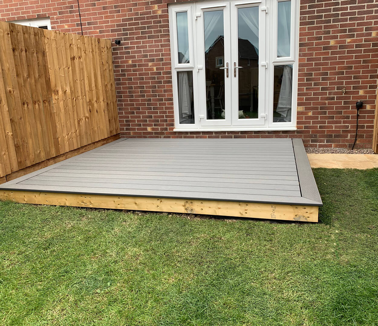 Stone grey composite decking area with dining table and bullnose edge