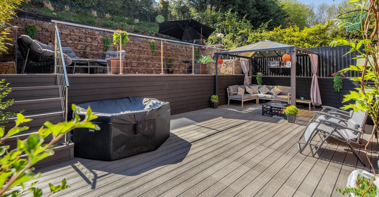 Large decking area with a hot tub and seating area