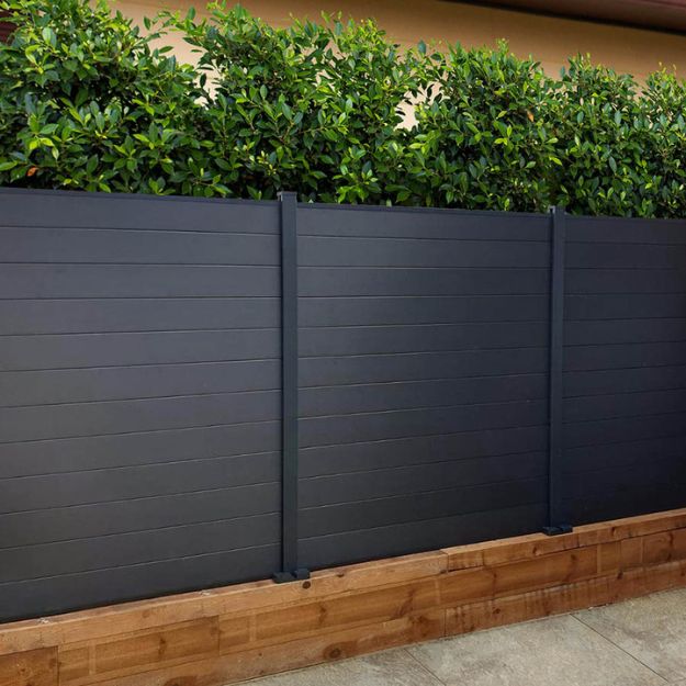 charcoal coloured composite fencing with foliage for privacy