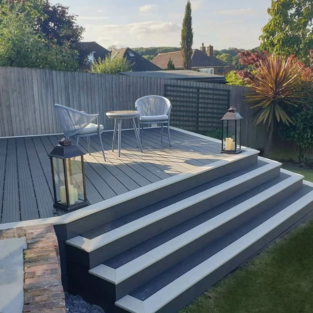 Stepped decking design with edge effect in a garden with table and chairs