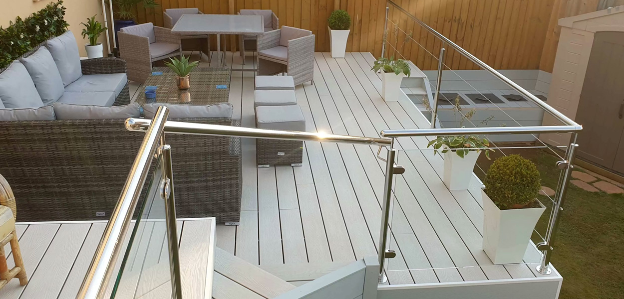 Composite decking boards installed on to a raised decking area with furniture and railings