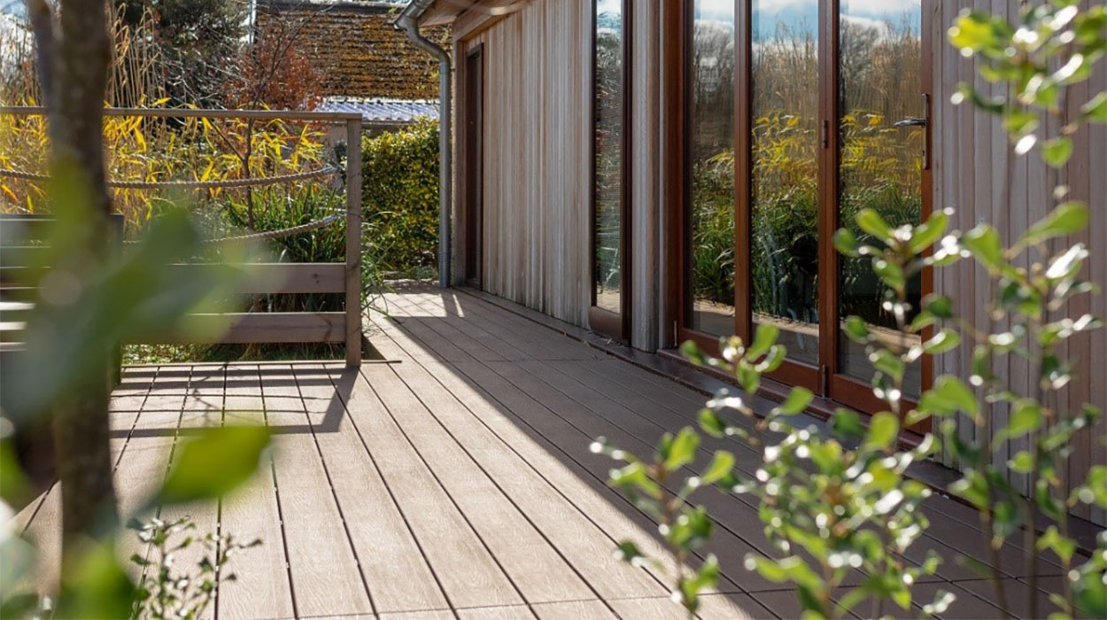 A composite decking with sliding patio windows on a sunny day