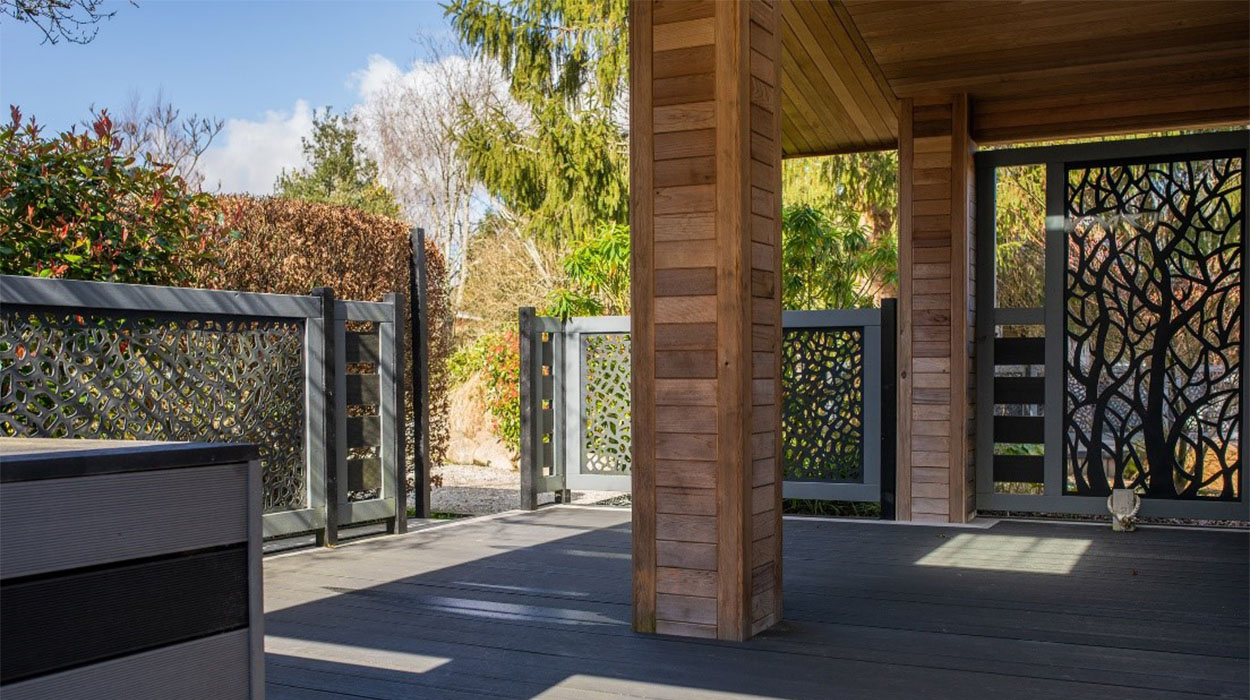 A mix of Charcoal and Grey Composite Decking Boards installed next to a luxury holiday home in the countryside on a sunny day.