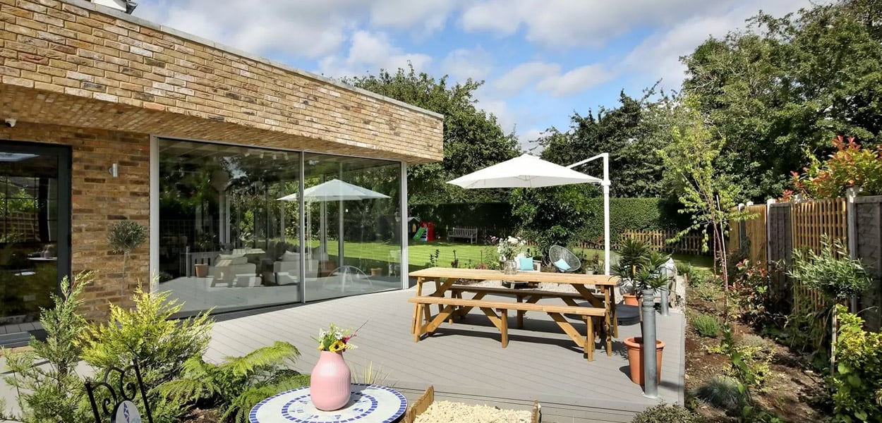 A large grey composite decking area with furniture on extending the living space
