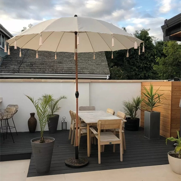 Charcoal composite decking boards laid in a small garden with furniture and plants on top