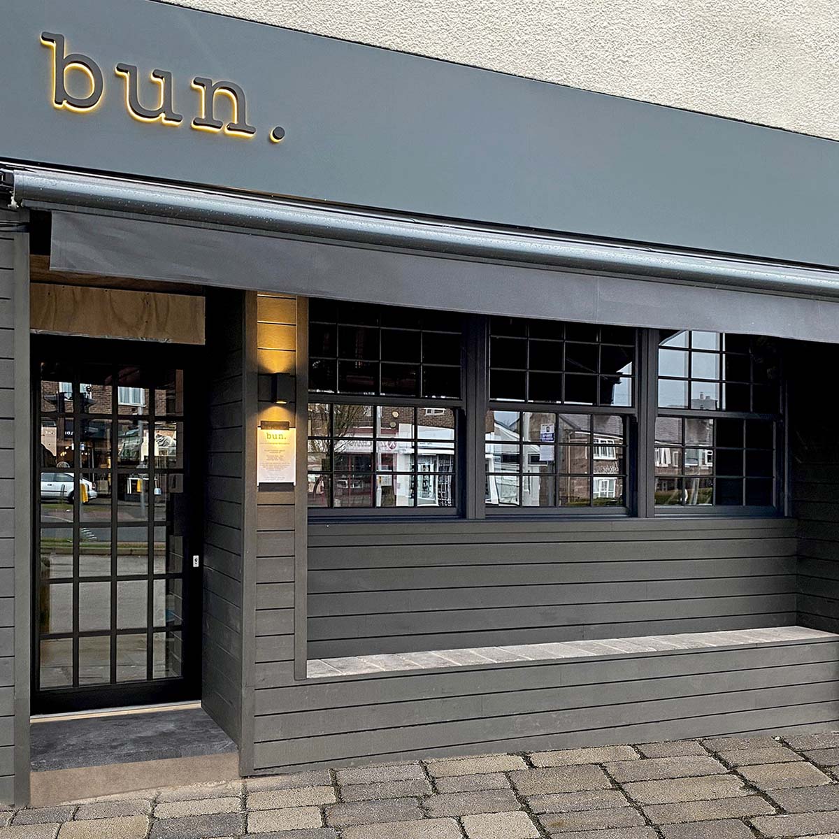 Composite Cladding Boards used on a contemporary café to both clad the walls and create an outside seating area for customers to sit and relax.