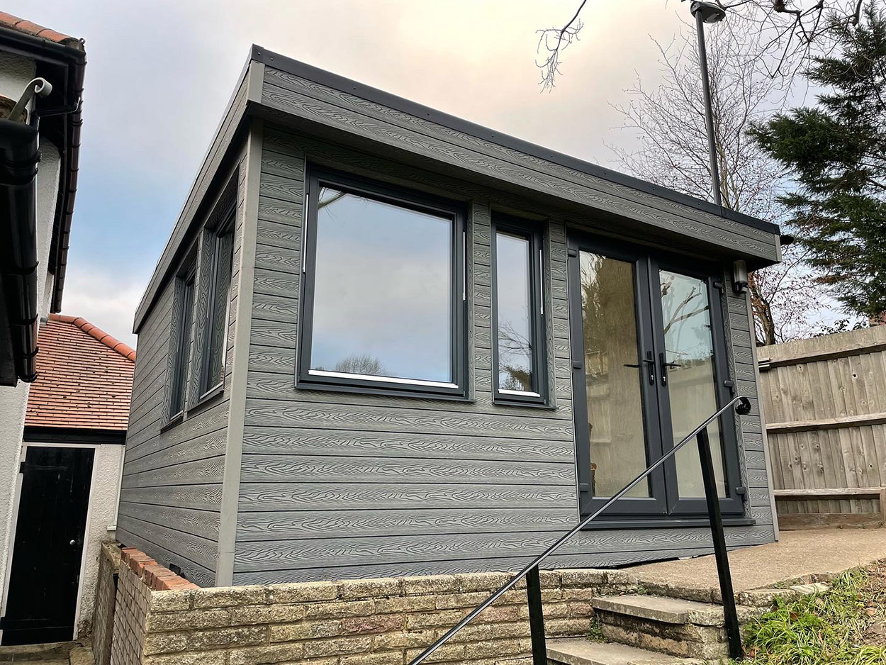 Stone Grey Woodgrain Wall Cladding has been used to finish the outside of a small garden office room