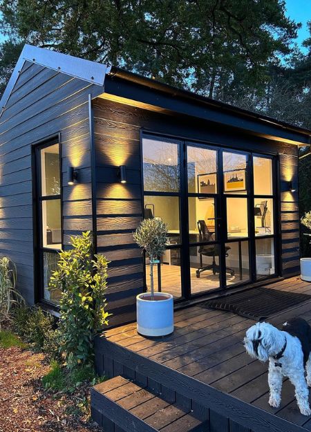 Garden room office with black cladding and decking.