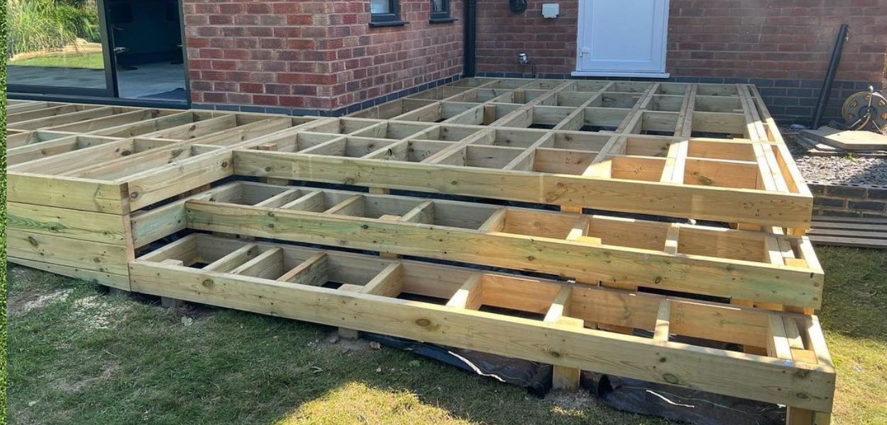 Raised timber decking frame for deck by a house