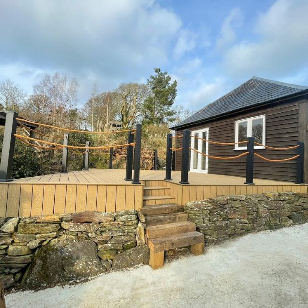 raised level decking with steps above stone wall