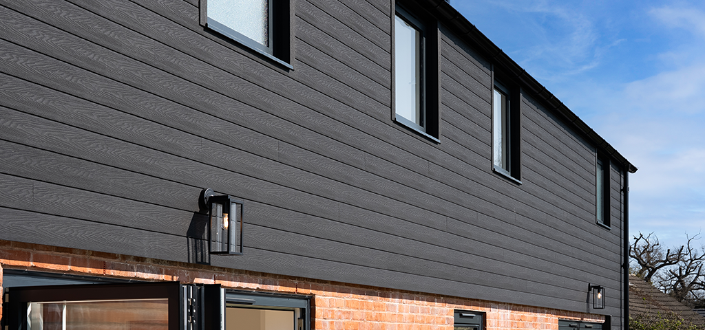 Close-up view of Cladco Signature Charcoal Composite Wall Cladding installed on upper exterior of a modern home