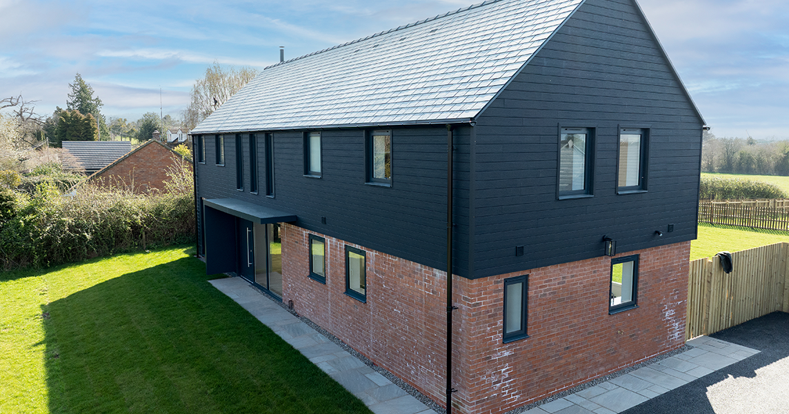 Exterior view of a modern house clad in Cladco Signature composite wall cladding in charcoal.