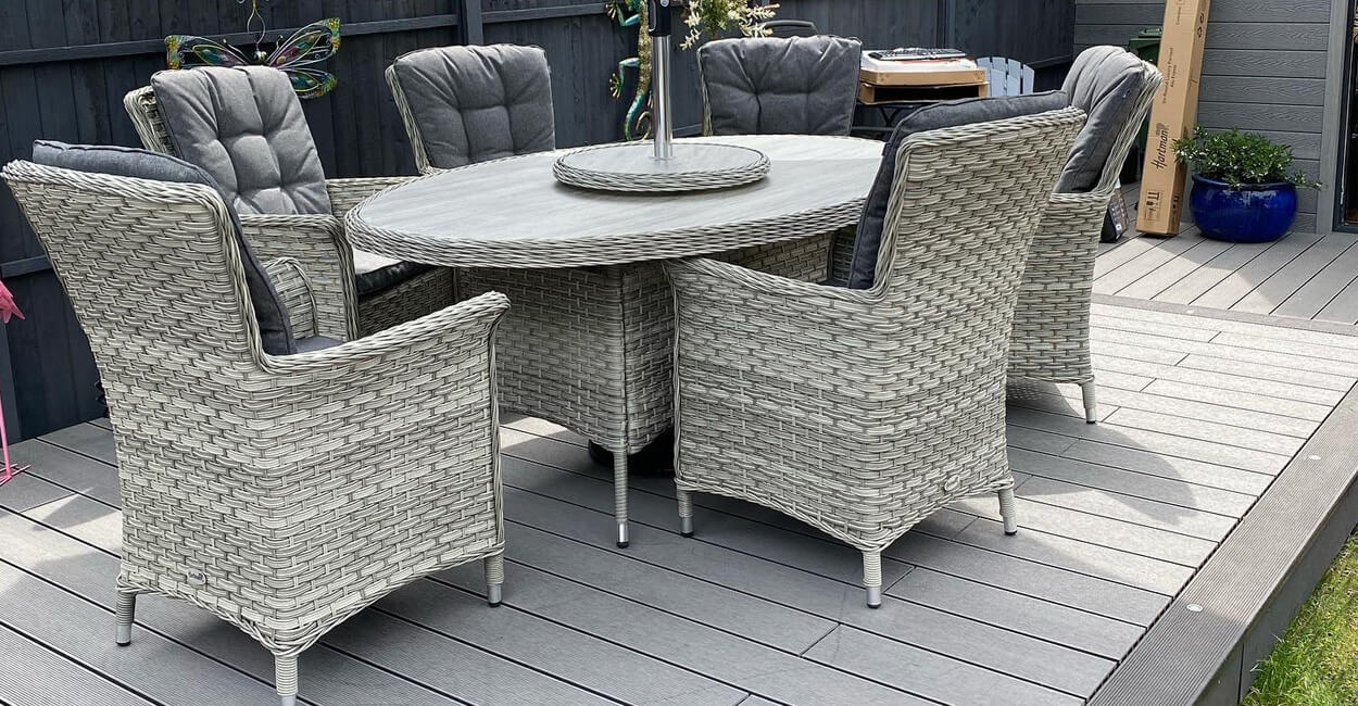 rattan dining set on light grey decking